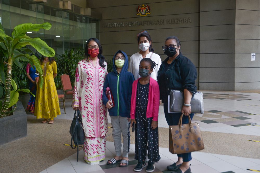 Malaysian mothers (from left) Adlyn Adam Teoh, Devi and Myra Eliza Mohd Danil are pictured at the National Registration Department in Putrajaya December 29, 2021. 