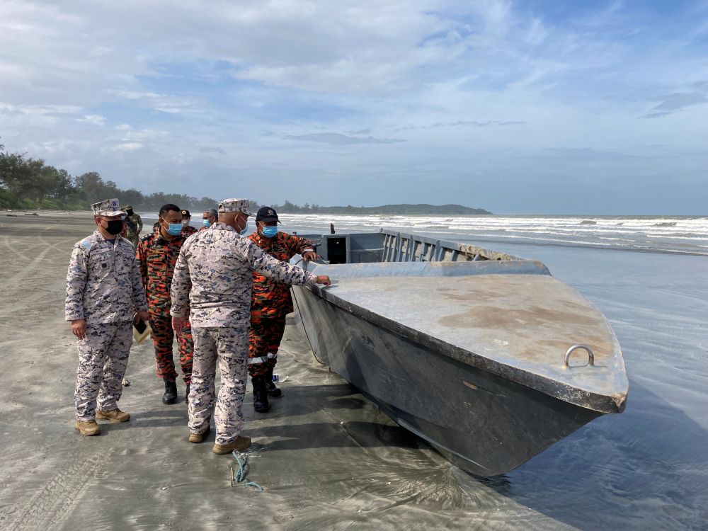 Officials inspect a boat that capsized and killed some of the people onboard, while other migrants remain missing in Kota Tinggi, Johor December 15, 2021. u00e2u20acu201d Reuters picnn
