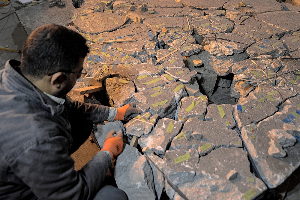 A worker at the Mosul Museum tries to reassemble from broken fragments a larger artefact bearing cuneiform inscriptions, at the museum in Iraq's northern city. u00e2u20acu2022 AFP pic