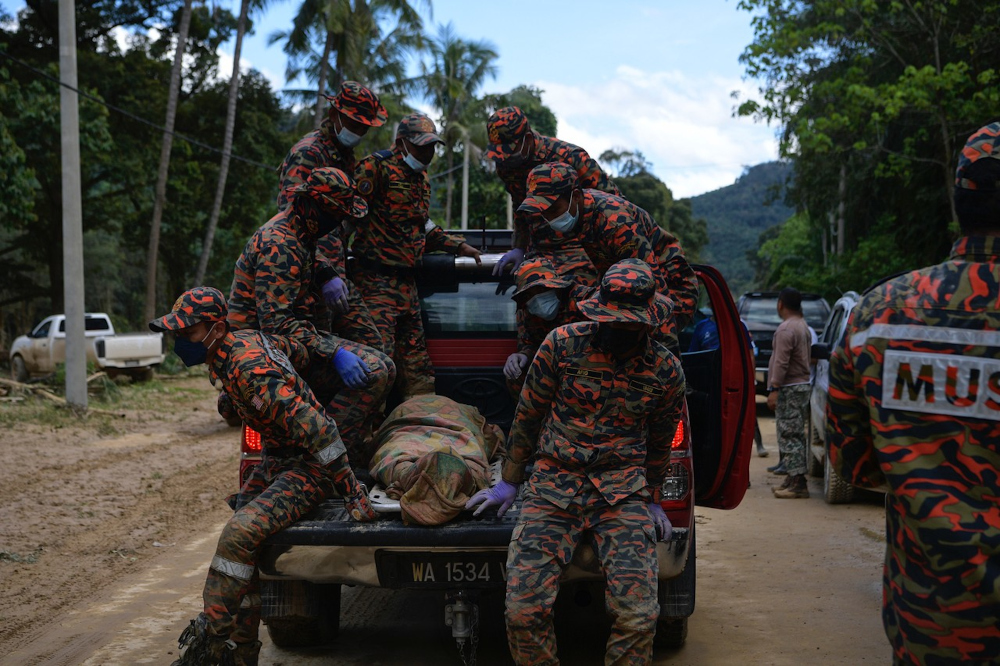 Malaysian Fire and Rescue Department personnel bringing out one of three bodies of mud flood victims in Sungai Telemong in Pahang, December 20, 2021. u00e2u20acu201d Bernama pic 