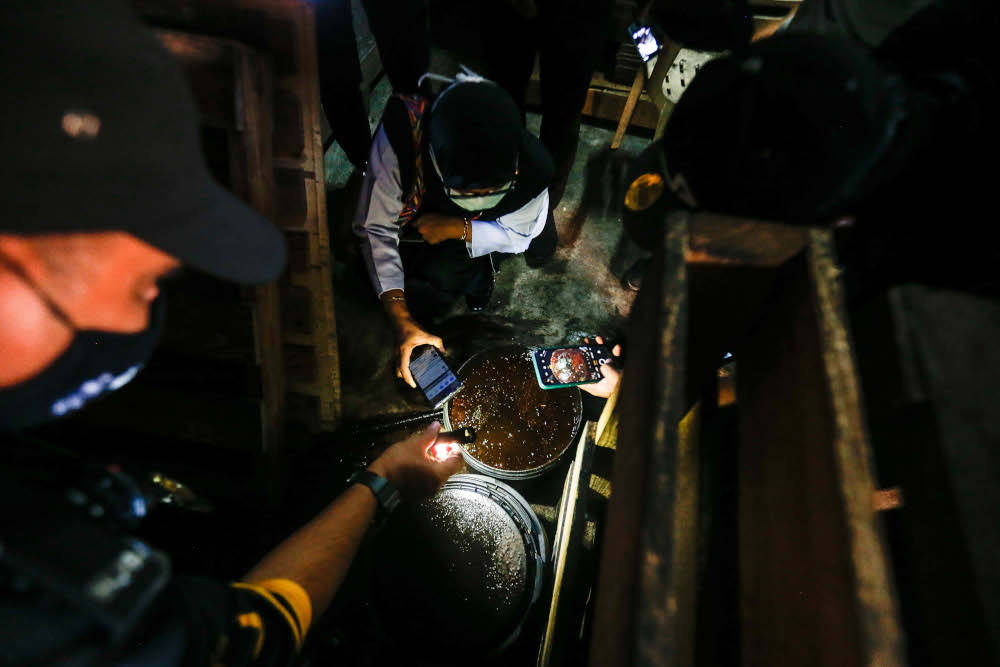 Penang Health Food Safety and Quality Division Environmental Health officer Mohd Wazir Khalid checks the food processing facilities during an operation at Pantai Acheh, Balik Pulau, December 28, 2021. u00e2u20acu201d Picture by Sayuti Zainudinn