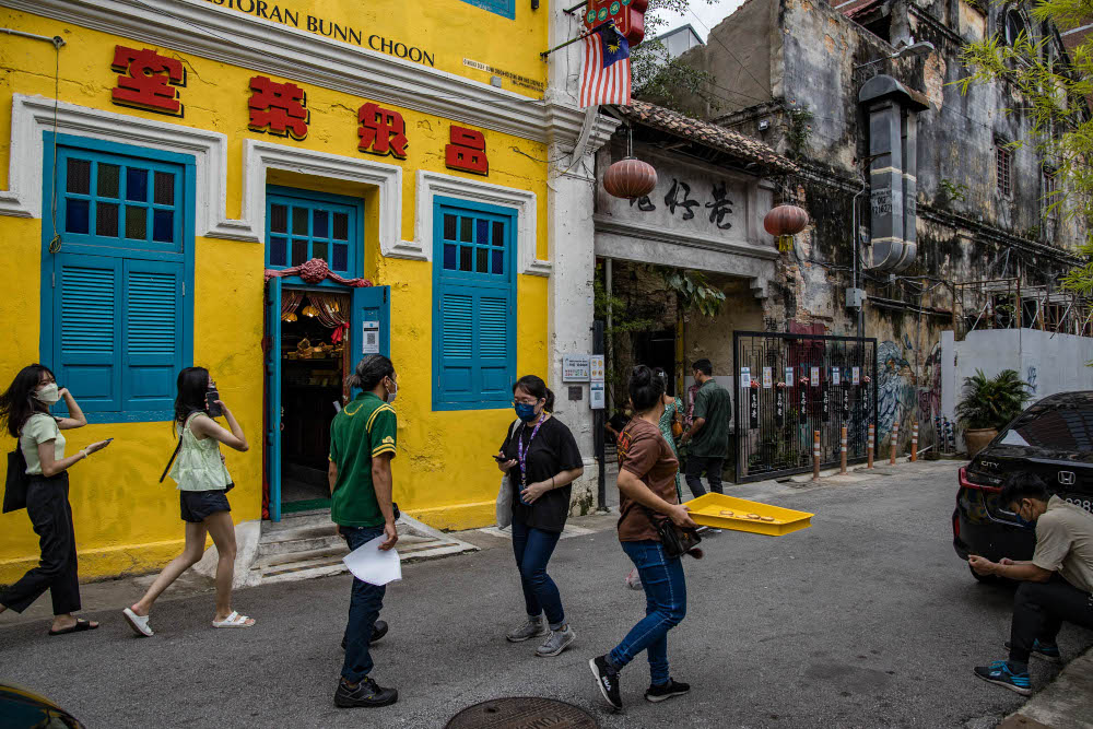 Visitors wear protective masks in a street in Kuala Lumpur, December 30, 2021. u00e2u20acu201d Picture by Firdaus Latif