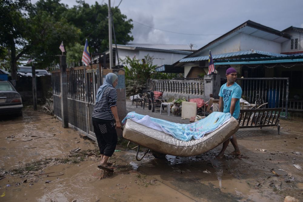 People are seen cleaning up their home as floodwaters recede in Puchong December 21, 2021. u00e2u20acu2022 Picture by Miera Zulyana 