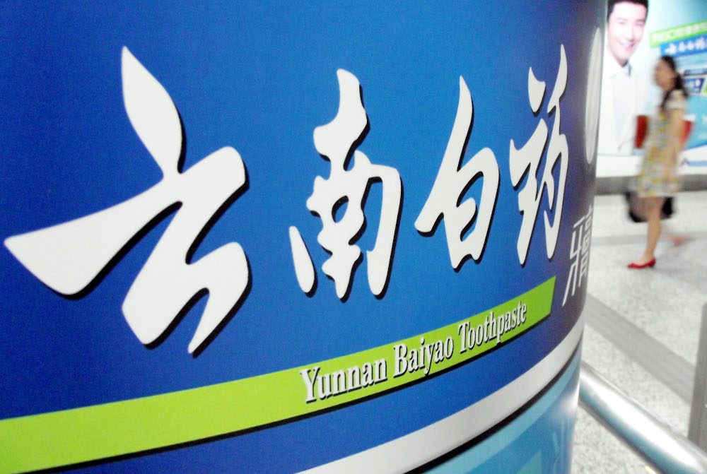 A pedestrian walks past an advertisement for Yunnan Baiyao toothpaste in Nanjing city, Jiangsu province in this file picture taken on June 15, 2014. u00e2u20acu201d Oriental Image pic via Reuters