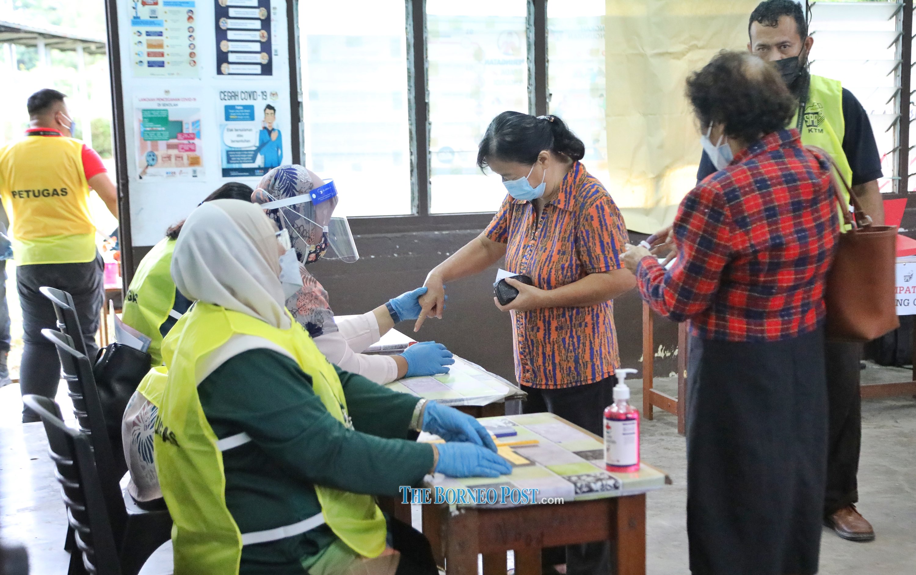 A voter at SK Garland in Kuching dips her finger into a bottle of indelible ink. u00e2u20acu201d Picture by Chimon Upon/Borneo Post