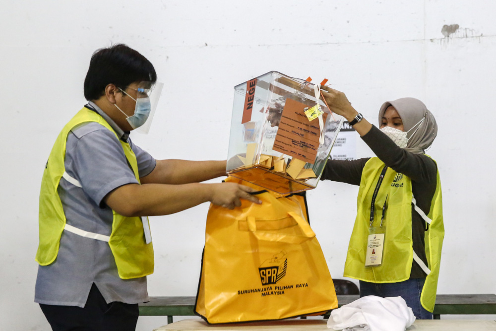 Election Commission (EC) personnel seal ballot box after polls closed during early voting at Dewan Badminton Kompleks Perumahan Polis Tabuan Jaya in Kuching December 14, 2021. u00e2u20acu201d Picture by Yusof Mat Isa