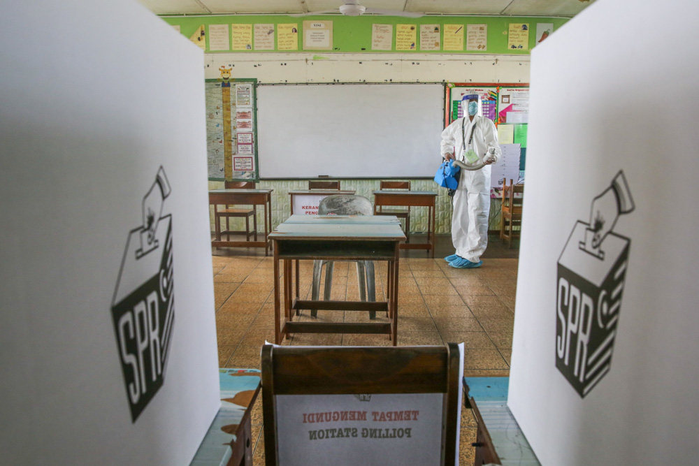 Health workers carry out sanitation works at a polling station ahead of the Sarawak state election tomorrow at Sekolah Kebangsaan Encik Buyong in Kuching, December 17, 2021. u00e2u20acu201d Picture by Yusof Mat Isa