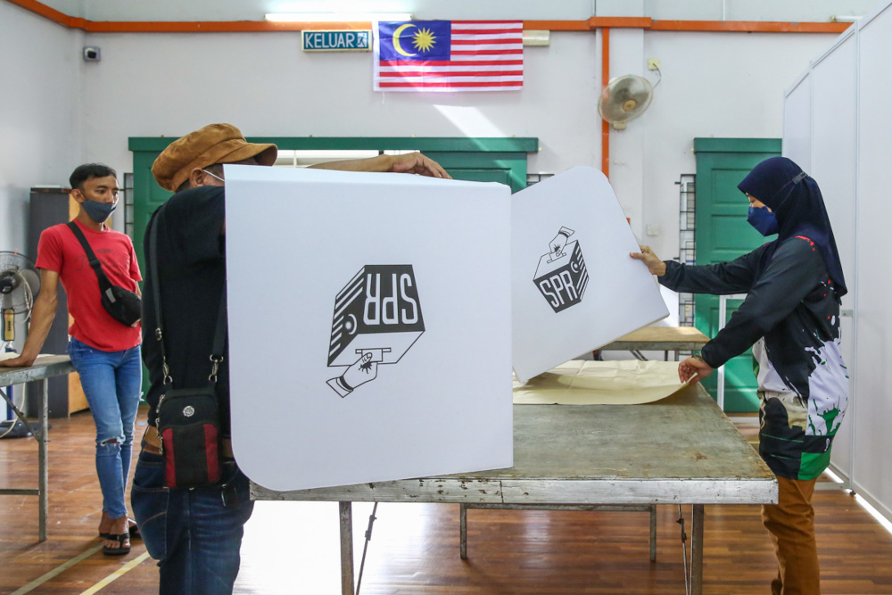 Election Commission (EC) officials preparing the voting centre ahead of the Sarawak state election which will take place tomorrow at Dewan Masyarakat Baru Kampung Lintang in Kuching, December 17, 2021. u00e2u20acu201d Picture by Yusof Mat Isa