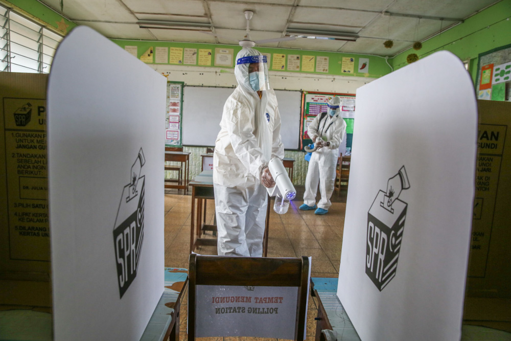 Health workers carry out sanitation works at a polling station ahead of the Sarawak state election tomorrow at Sekolah Kebangsaan Encik Buyong in Kuching, December 17, 2021. — Picture by Yusof Mat Isa