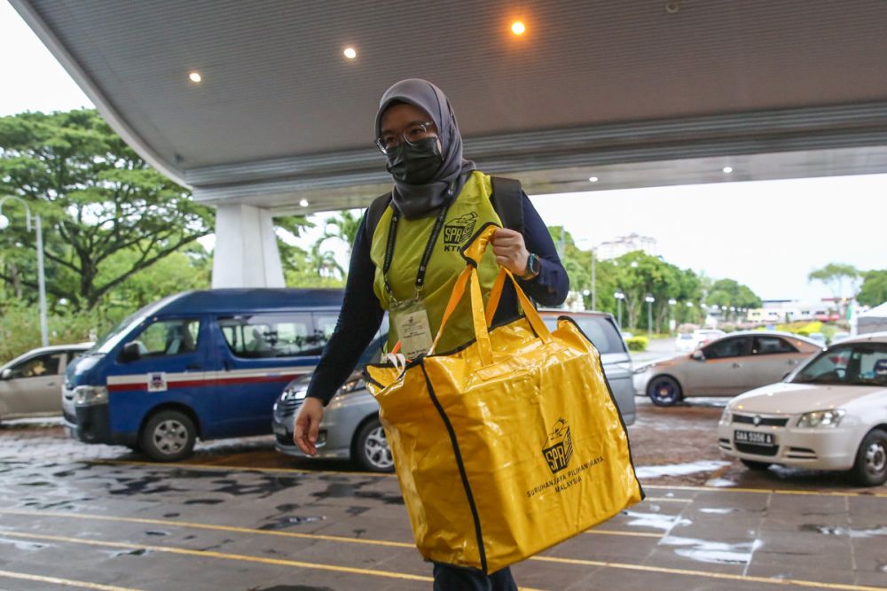 An Election Commission personnel delivers a ballot box to the collation centre at Majlis Bandaraya Kuching Selatan December 18, 2021. u00e2u20acu2022 Picture by Yusof Mat Isa