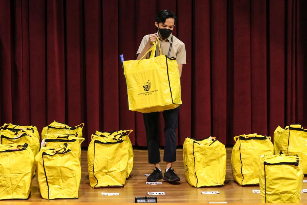 An Election Commission personnel delivers a ballot box to the collation centre at Majlis Bandaraya Kuching Selatan December 18, 2021. u00e2u20acu2022 Picture by Yusof Mat Isa