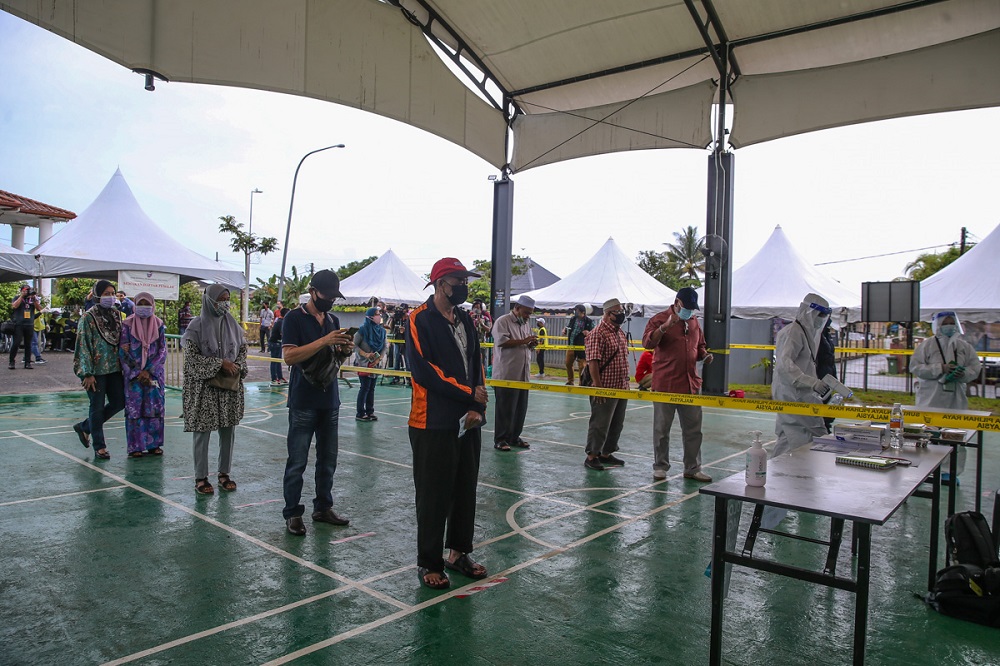 People queue up to cast their votes during at the Kompleks Sukan Satok polling centre in Kuching December 18, 2021. u00e2u20acu2022 Picture by Yusof Mat Isa