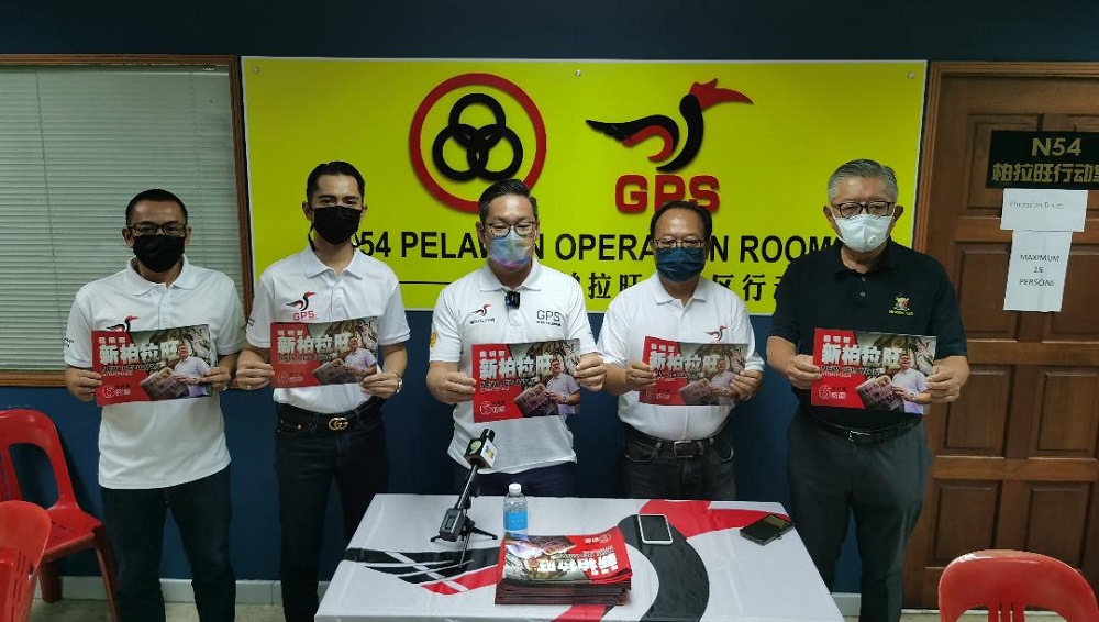 Tiang (centre) shows his manifesto. At right is Sarawak United Peopleu00e2u20acu2122s Party (SUPP) Pelawan chairman Clarence Ting. u00e2u20acu201d Borneo Post Online pic
