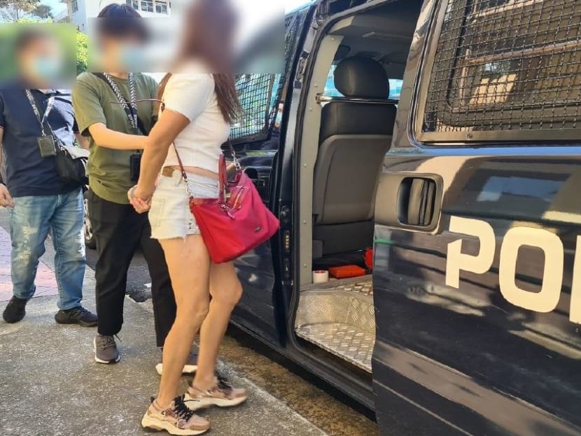 A woman is seen being led into a police vehicle after an enforcement check was conducted at an unlicensed massage establishment along Balestier Road. u00e2u20acu2022 Picture courtesy of Singapore Police Force