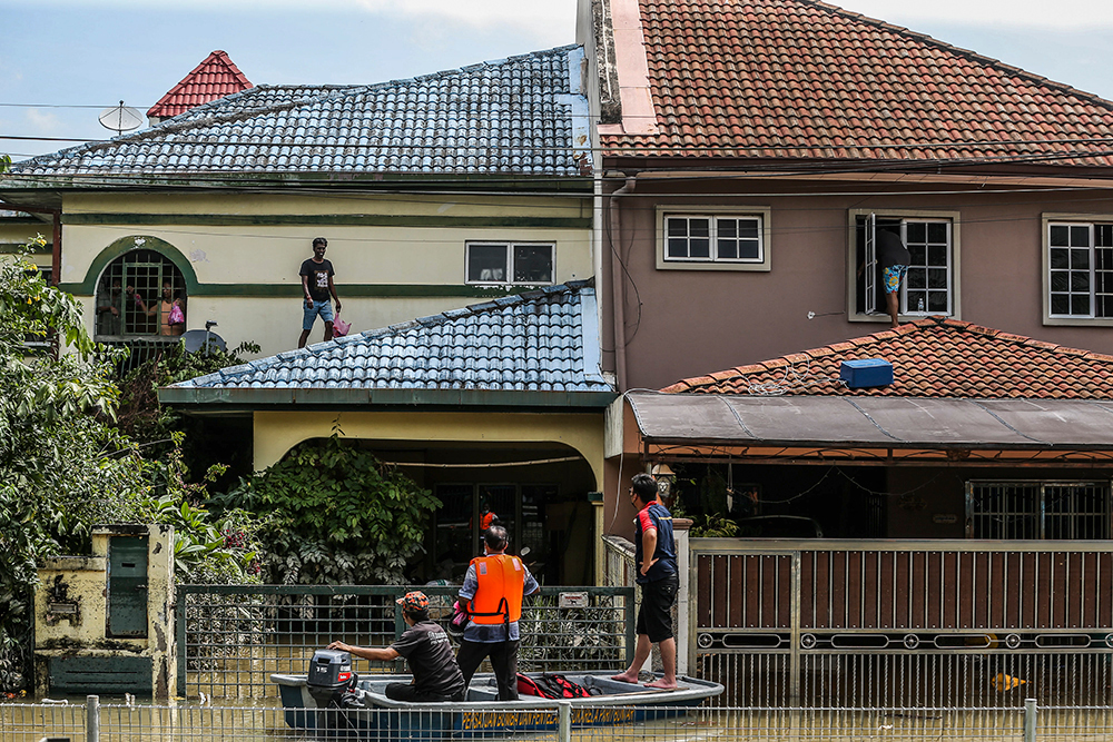 Flood victims wait on the roof of their home for assistance in Taman Sri Muda Section 25 Shah Alam December 20, 2021. u00e2u20acu201d Picture by Hari Anggara