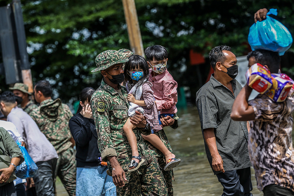 Search and rescue personnel help evacuate flood victims in Taman Sri Muda, Shah Alam December 20, 2021. — Picture by Hari Anggara