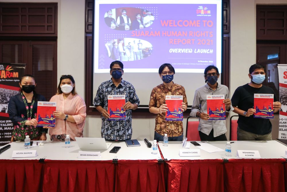 Members of Suara Rakyat Malaysia pose with copies of the 2021 Human Rights Report in Kuala Lumpur December 1, 2021. u00e2u20acu201d Picture by Ahmaf Zamzahurinn