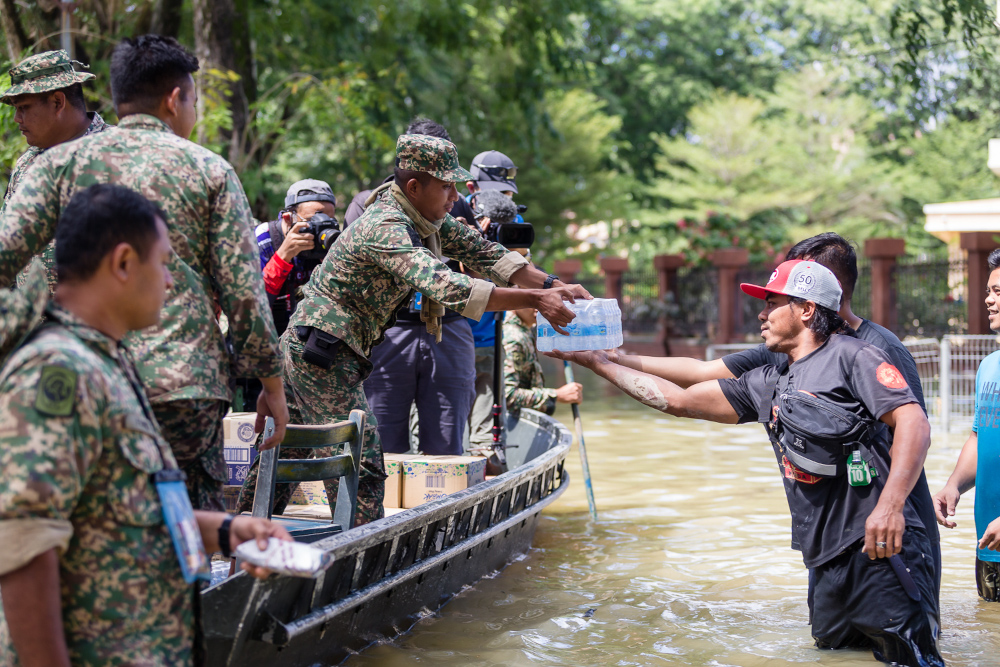  Flood victims receive drinking water from volunteers and rescuers at Taman Sri Muda, Shah Alam December 21, 2021. u00e2u20acu201d Picture by Devan Manuel