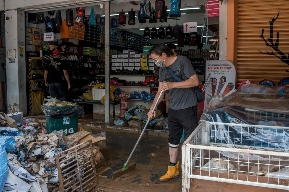 Ivan Loh cleans his mud-filled shop after floodwaters recede in Taman Sri Nanding, Hulu Langat December 21, 2021. u00e2u20acu201d Picture by Shafwan Zaidon