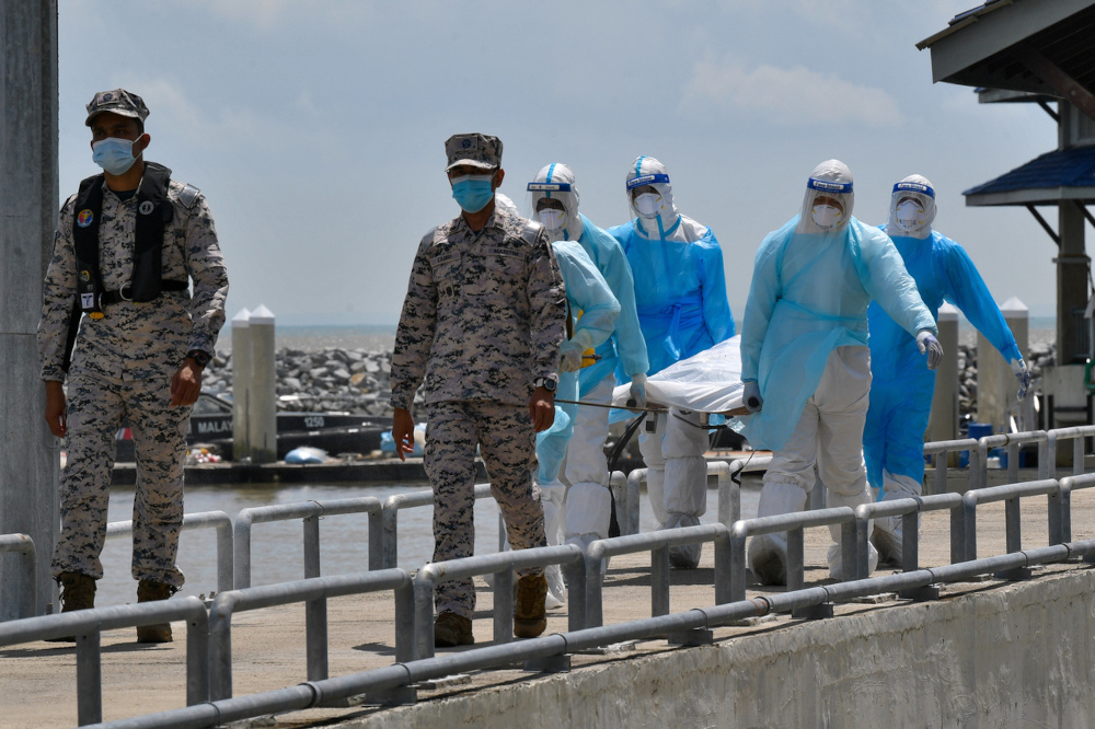 Health Ministry personnel carry the body believed to be a victim of the Tanjung Balau boat capsize incident at the LKIM Fisheries Complex near Tanjung Batu Layar in Johor, December 17, 2021. u00e2u20acu201d Bernama pic 