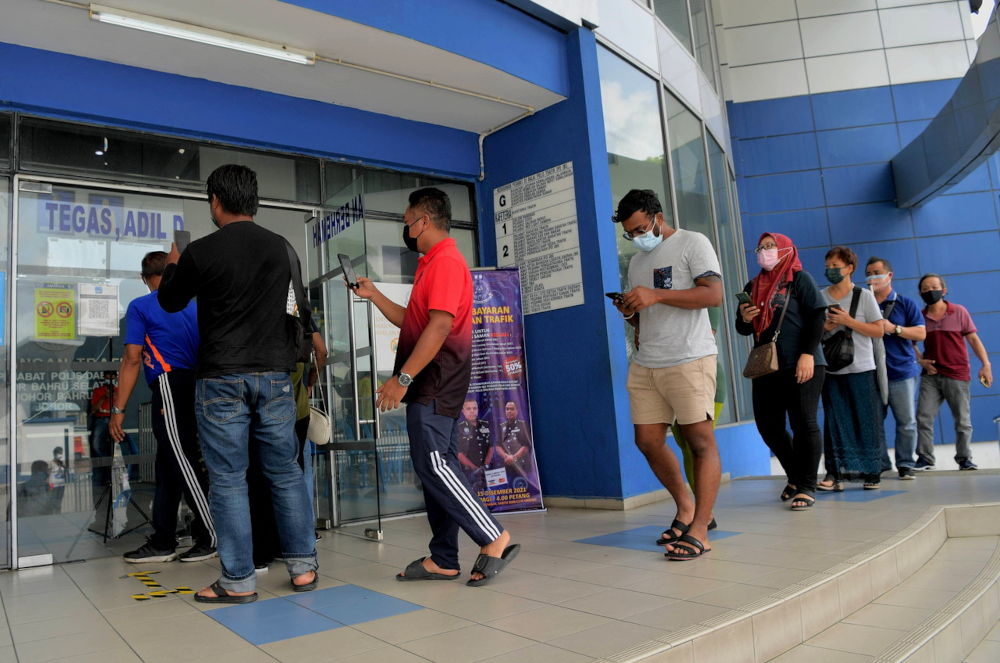 People wait their turn to pay outstanding traffic summonses at the South Johor Baru district police headquarters, December 10, 2021. u00e2u20acu201d Bernama pic 