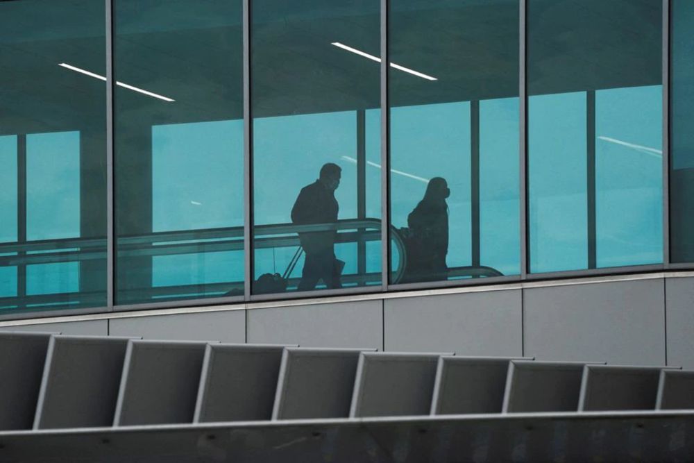Travellers pull rolling luggage behind them inside Tom Bradley International Terminal at Los Angeles International Airport (LAX) during the holiday season as the coronavirus disease (Covid-19) Omicron variant threatens to increase case numbers in Los Ange