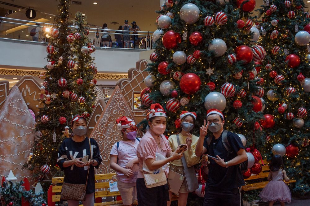 People pose for pictures with Christmas decorations at the Mid Valley Megamall in Kuala Lumpur December 23, 2021. u00e2u20acu201d Picture by Shafwan Zaidon