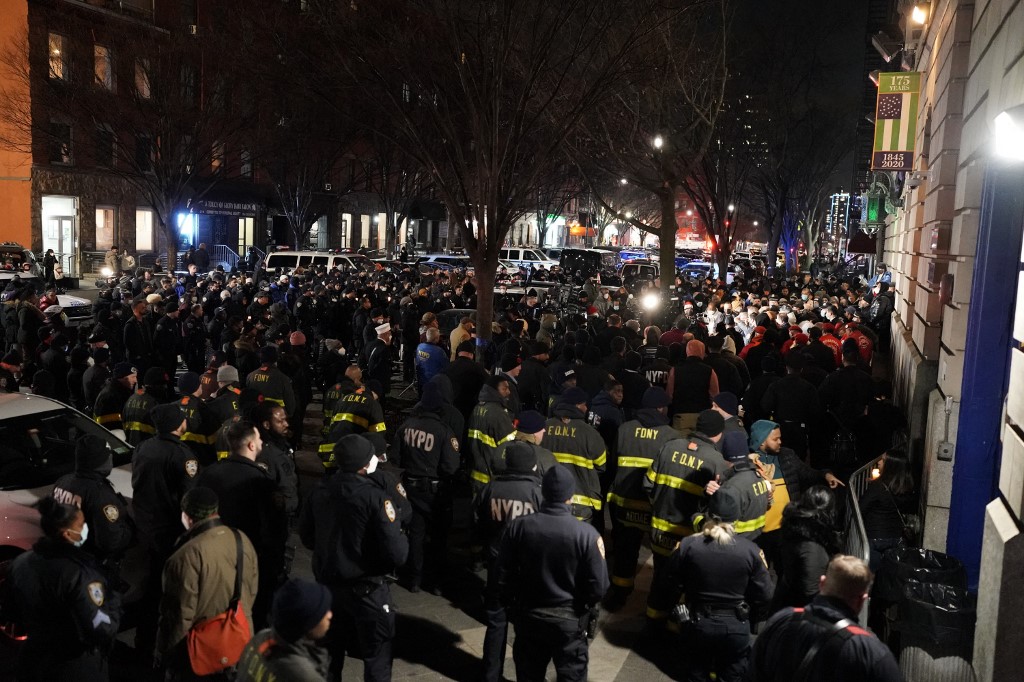 People attend a vigil following the shooting of two police officers in Harlem, New York on January 22, 2022. u00e2u20acu201d AFP pic