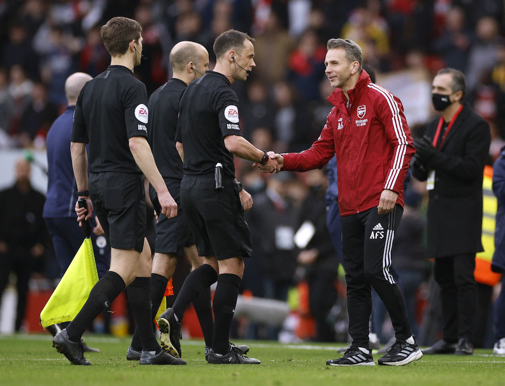 Arsenal assistant coach Albert Stuivenberg shakes hands with referee Stuart Attwell after the match, January 1, 2022. u00e2u20acu201d Action Images via Reuters