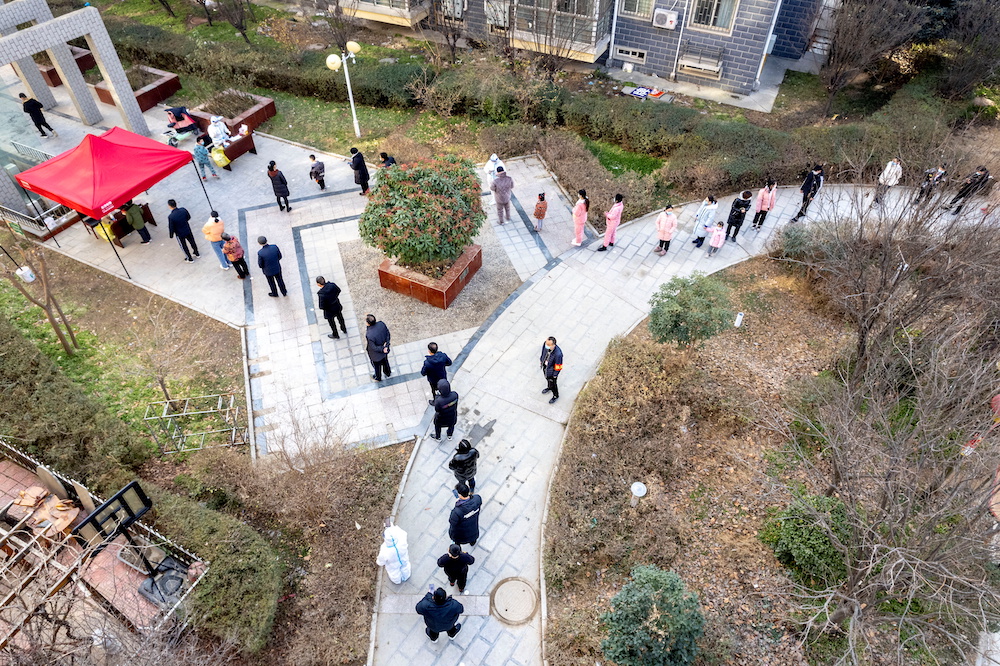 People line up during the fifth round of nucleic acid testing at a residential compound following the Covid-19 outbreak in Anyang, Henan province, China January 15, 2022. u00e2u20acu201dcnsphoto via Reuters