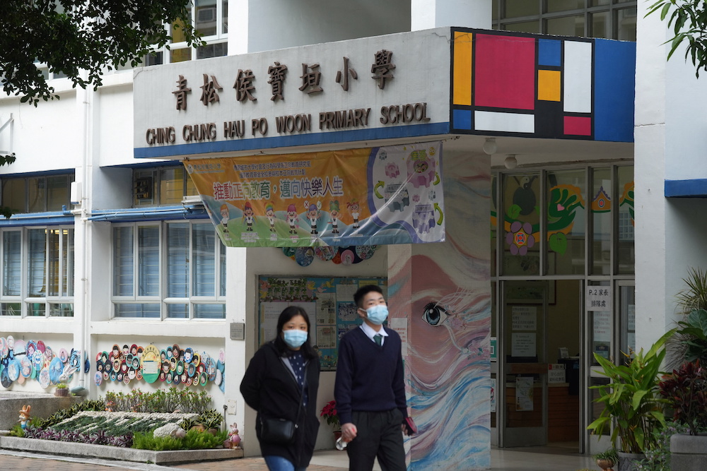People wearing face masks walk outside a primary school, following coronavirus disease (Covid-19) infections in Hong Kong, China January 11, 2022. u00e2u20acu201d Reuters pic