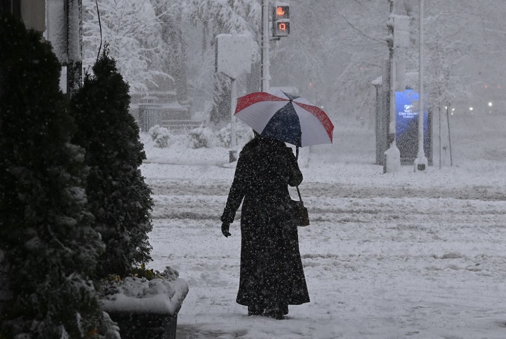 A person walks holding an umbrella as snow falls during a winter storm over the capital region in Washington, DC January 3, 2022. u00e2u20acu201d AFP pic