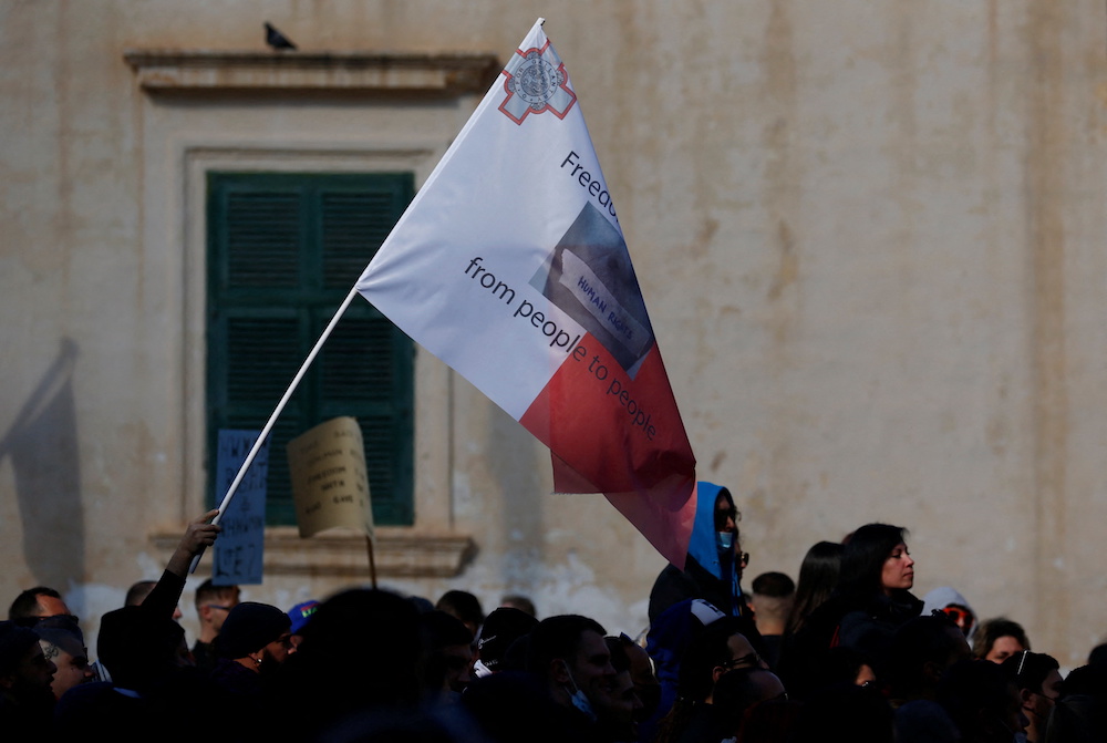A demonstrator holds a flag during a protest in Valletta, Malta January 16, 2022. u00e2u20acu201d Reuters picnn
