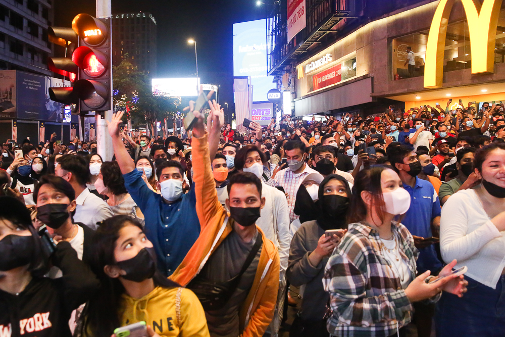 People gather for the New Year countdown along Jalan Bukit Bintang in Kuala Lumpur December 31, 2021.