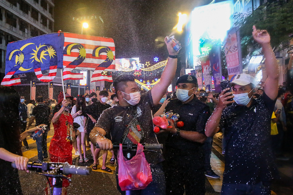 Policemen try to disperse the crowd gathered for the New Year countdown along Jalan Bukit Bintang in Kuala Lumpur December 31, 2021. u00e2u20acu201d Picture by Choo Choy May