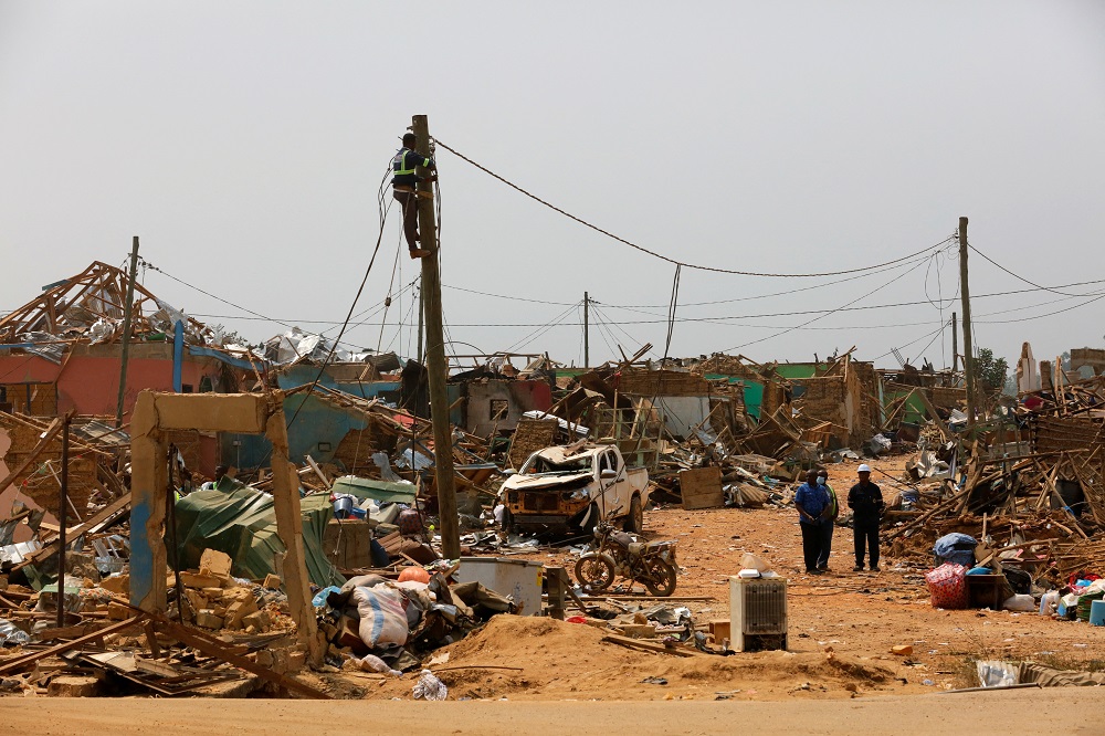A worker from Ghana's electricity company removes power cables that were damaged when a vehicle carrying mining explosives detonated along a road in Apiate, Ghana January 21, 2022. u00e2u20acu201d Reuters