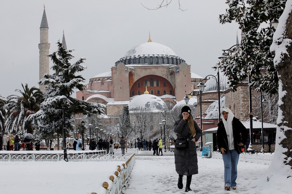 Tourists walk along Sultanahmet Square as Ayasofya-i Kebir Camii or Hagia Sophia Grand Mosque is seen in the background during a snowy day in Istanbul January 24, 2022. u00e2u20acu201d Reuters pic