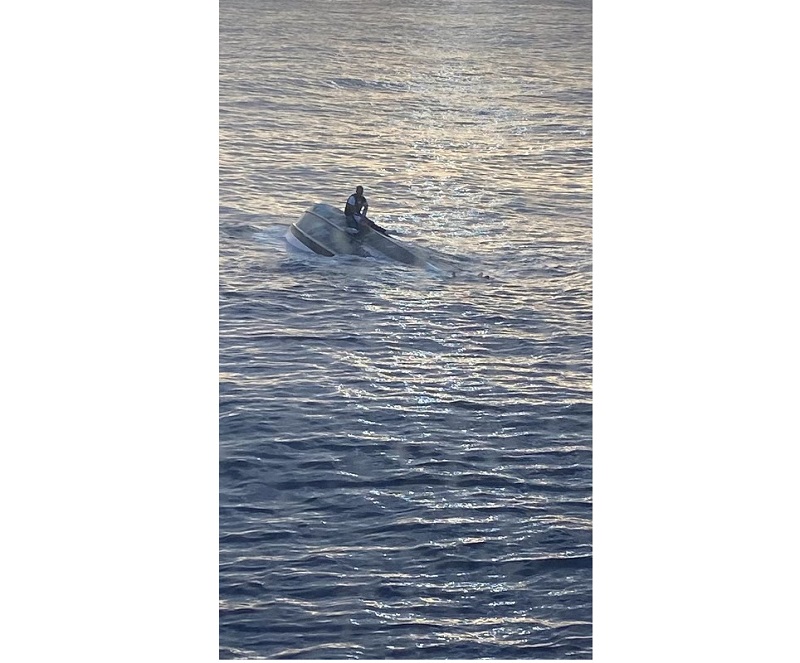 A man, who says he was one of 40 people who left Bimini, Bahamas, on Saturday, sits on a capsized boat off the coast of Fort Pierce Inlet, Florida January 25, 2022. u00e2u20acu201d Picture courtesy of US Coast Guard/Handout via Reuters