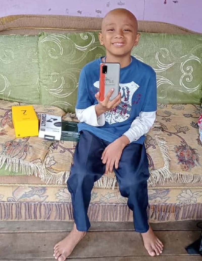 Azhar with his smartphone gifted to him by Make a Wish Malaysia to help him and his family cope with his multiple hospital admissions. u00e2u20acu201d Picture by Irena Tan