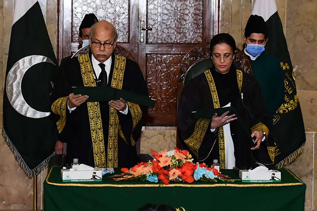 This handout photograph taken on January 24, 2022 shows chief justice Gulzar Ahmed (left) administering the oath to justice Ayesha Malik as Pakistan's first female supreme court judge in Islamabad. u00e2u20acu201d Picture from Pakistan Press Information Dept via AFPn