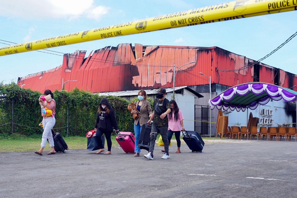 Employees leave Double O nightclub where at least 18 people were killed in clashes between two groups, in Sorong in Indonesia's West Papua province on January 25, 2022. u00e2u20acu201d AFP pic