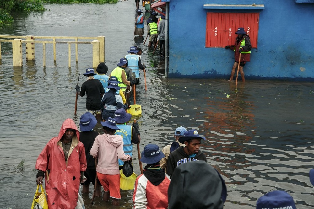 People walk through flood water after several houses were affected by rising water following heavy rains in 67 Hectares neighbourhood in Antananarivo, Madagascar January 24, 2022. u00e2u20acu201d AFP pic