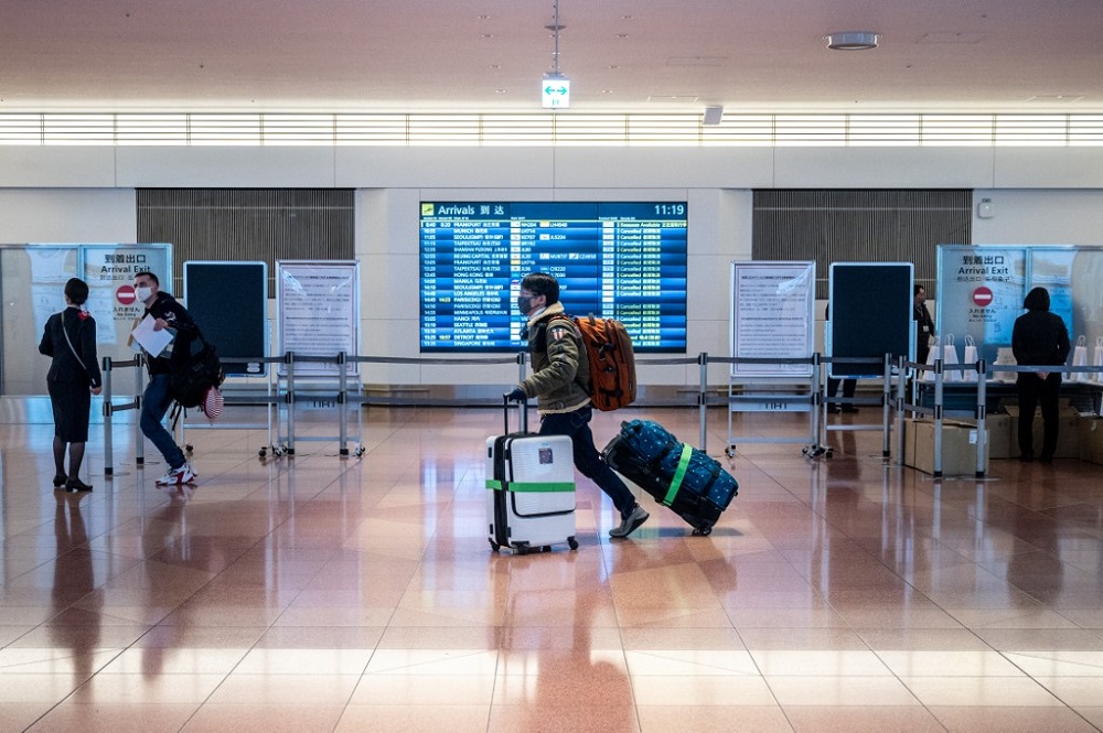 A passenger walks with luggage at the arrivals hall of Tokyo's Haneda international airport on January 25, 2022. u00e2u20acu201d AFP pic