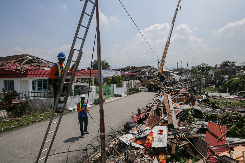 With several houses at Kampung Tawas, Ipoh destroyed following strong winds yesterday, steps are being undertaken to remove the debris and restore electricity in the area January 31, 2022. — Picture by Farhan Najib
