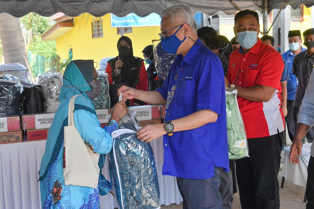 Prime Minister Datuk Seri Ismail Sabri Yaakob gives out flood aid to a resident of Kampung Guai in Bera January 23, 2022. u00e2u20acu201d Bernama pic 