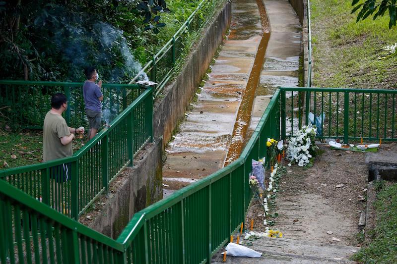 Visitors to a park in the Greenridge Crescent area on January 23, 2022, praying next to a drain where the bodies of two boys were said to have been found. u00e2u20acu201d TODAY pic