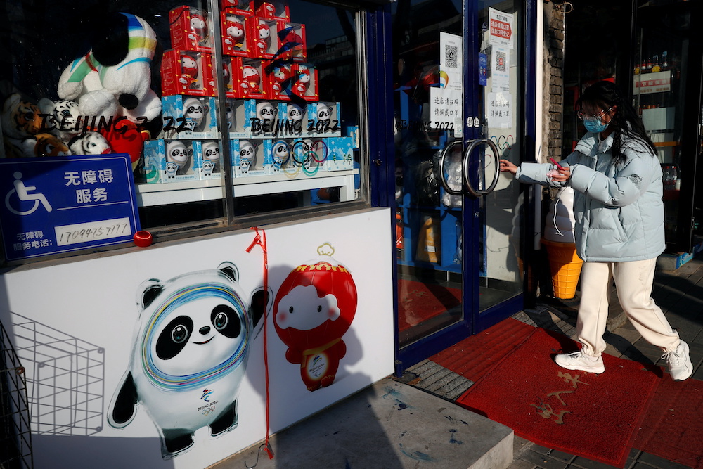 A man walks at a hutong alley decorated with lanterns and a sign of the Beijing 2022 Winter Olympics, ahead of the opening ceremony of the Games and the Chinese Lunar New Year holiday, in Beijing, China January 29, 2022. u00e2u20acu201d Reuters picnn
