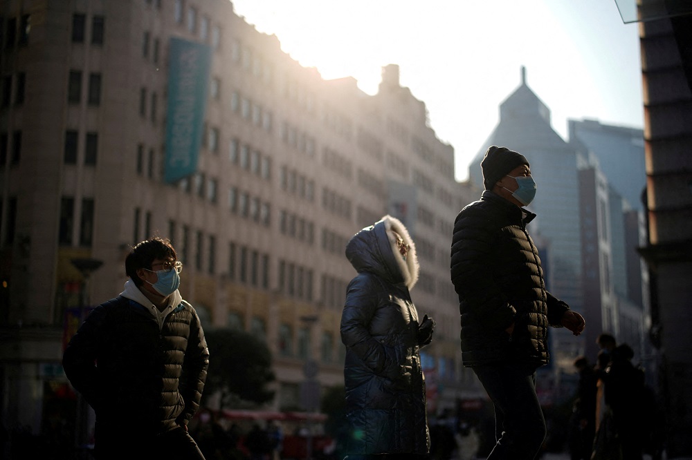 People wearing protective face masks walk on a street in Shanghai December 30, 2021. u00e2u20acu2022 Reuters pic