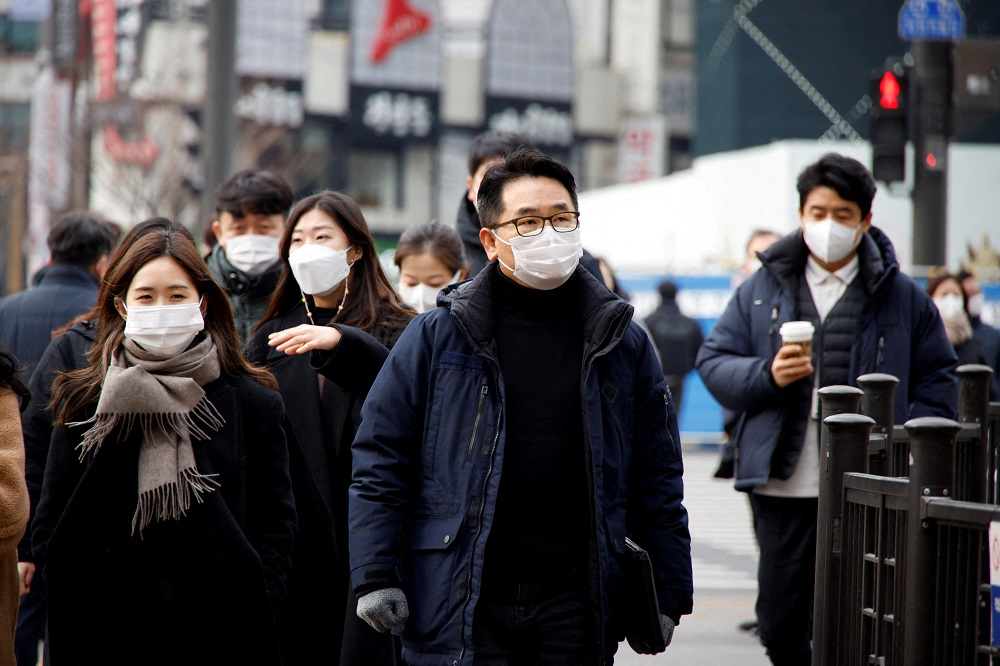 People wearing masks walk on a street in downtown Seoul, South Korea January 5, 2022. u00e2u20acu2022 Reuters file pic