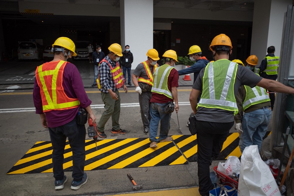 Construction workers stand next to where the slogan u00e2u20acu02dccold bloodu00e2u20acu2122 was visible on the ground after covering it with metal sheeting, as one of the last public tributes in Hong Kong, January 29, 2022. u00e2u20acu201d AFP picnn